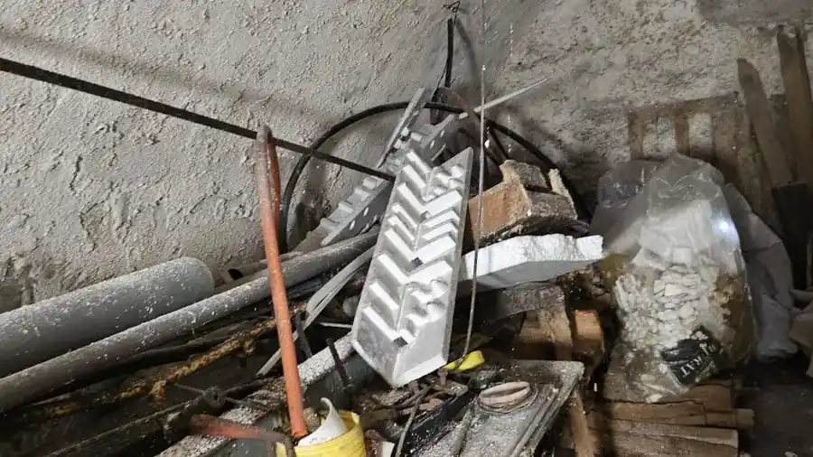 Cave voûtée encombrée de gravats et de bois avant curage complet
